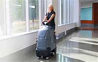 woman with a chariot floor scrubber
